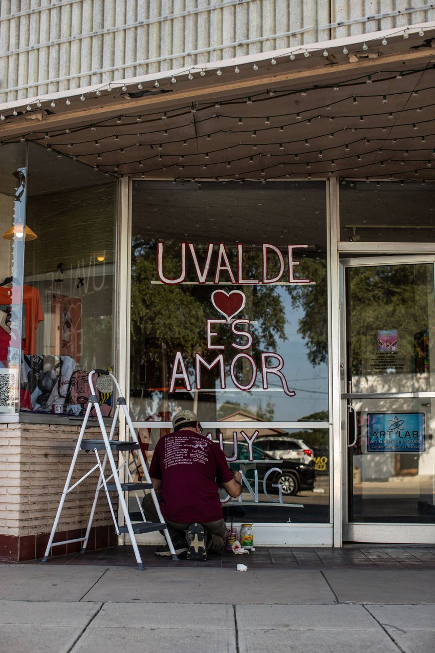 Avel Ortiz, 55, puts the final touches on a window message in front of his business in Ulvade on May 29, 2022. Ortiz said he…